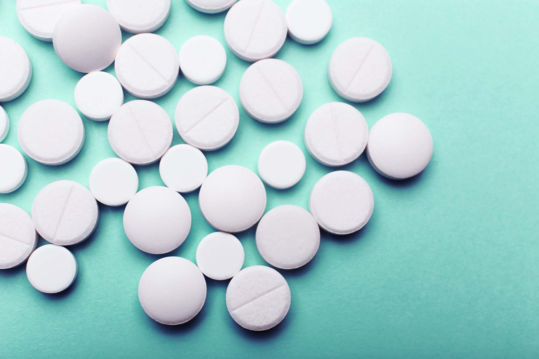 Heap of pills on color background